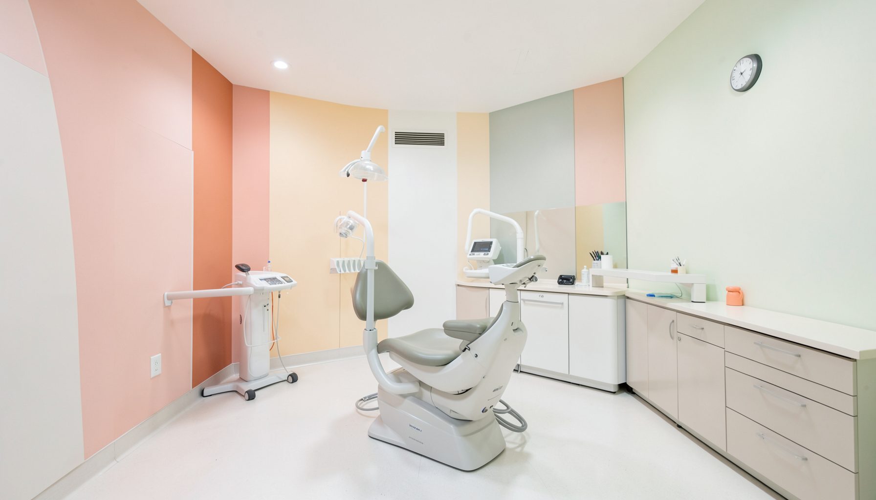 Geniş ve düzenli bir diş kliniği tedavi odası; açık renkli duvarlar, modern diş ünitesi, yumuşak aydınlatma ve temiz çizgilerle sakin bir ortam.
