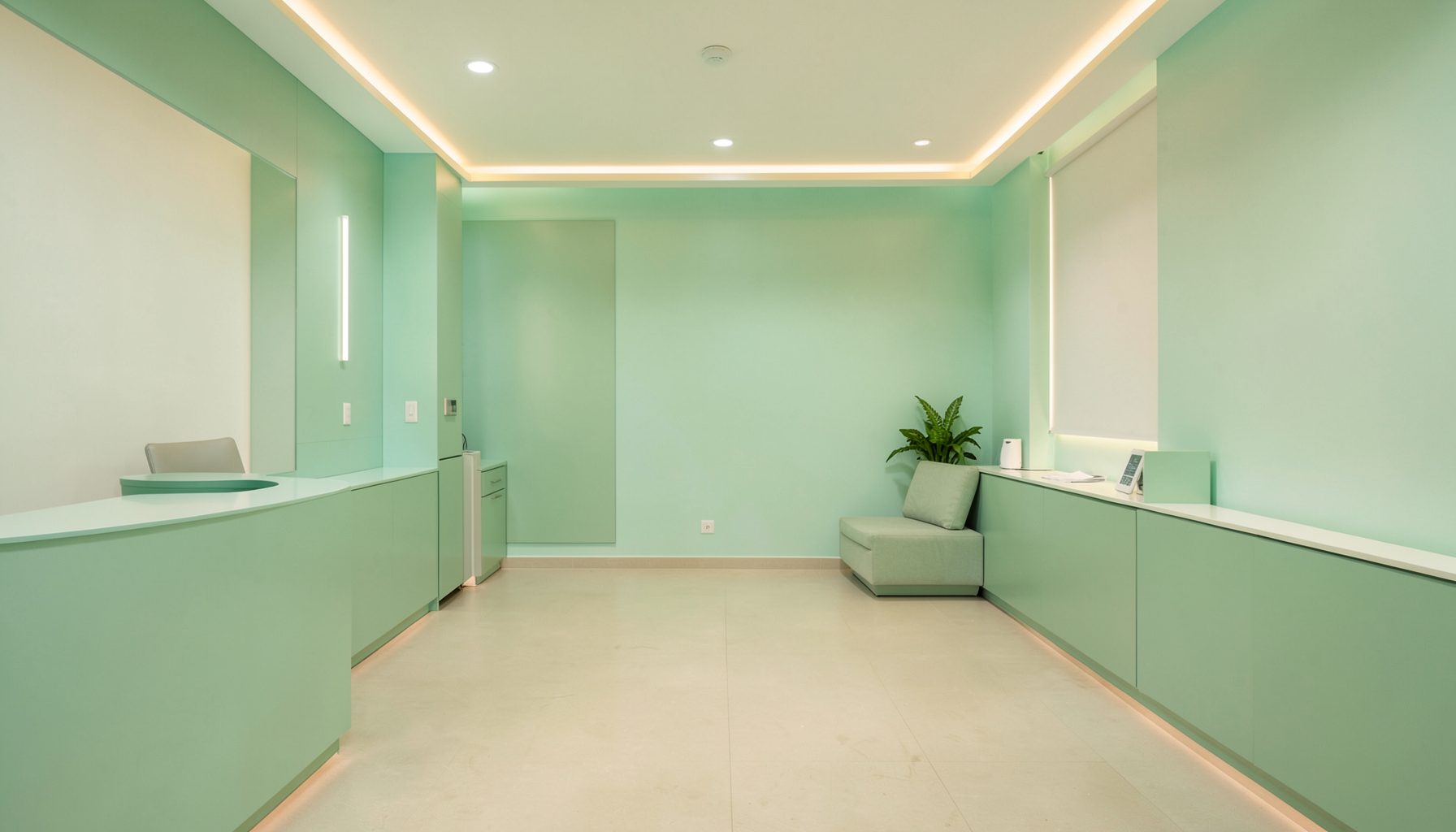 Sakin lacivert ve turkuaz tonlarında, ferah ve modern bir diş kliniği bekleme alanının sıcak ışıklı görüntüsü